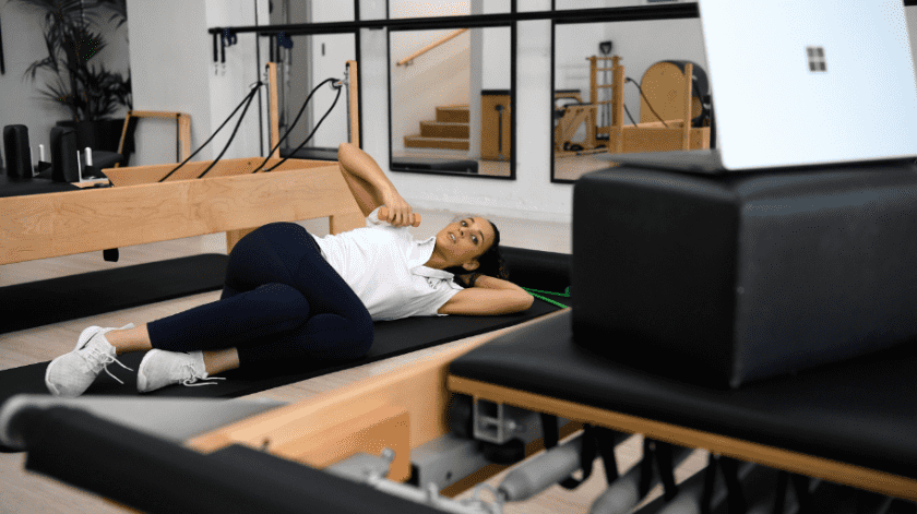 La fisioterapeuta australiana Tara Dighton, haciendo una clase de Pilates para pacientes en casa utilizando en la mano una mancuerna.(EFE/EPA/BIANCA DE MARCHI)