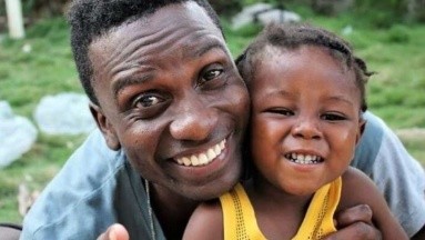Encuentra bebé en un contenedor de basura durante sus vacaciones en Haití y decide adoptarlo