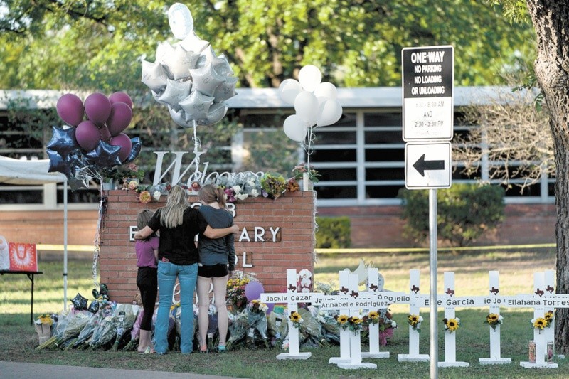 Una familia rinde homenaje frente a las cruces que llevan los nombres de las v�ctimas de un tiroteo en la escuela primaria Robb, en Uvalde, Texas.